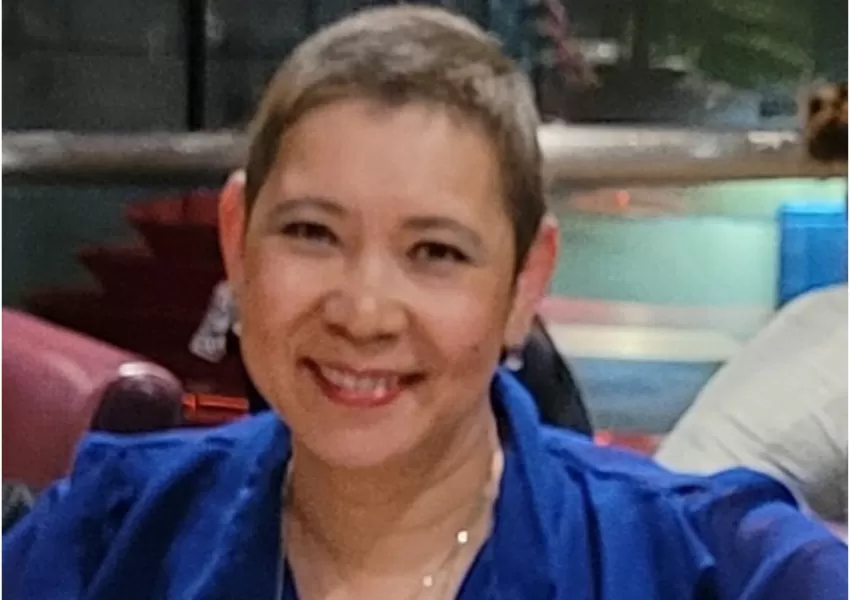 Woman wearing blue blouse smiling to camera