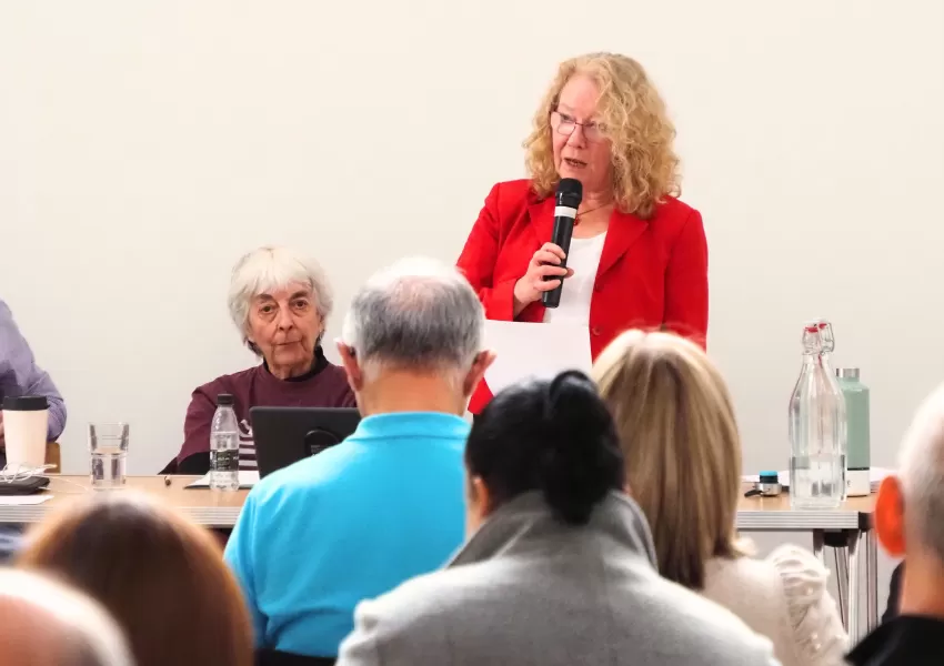 Cllr Alison Moore speaking into a microphone to the audience at the Barnet Food Summit