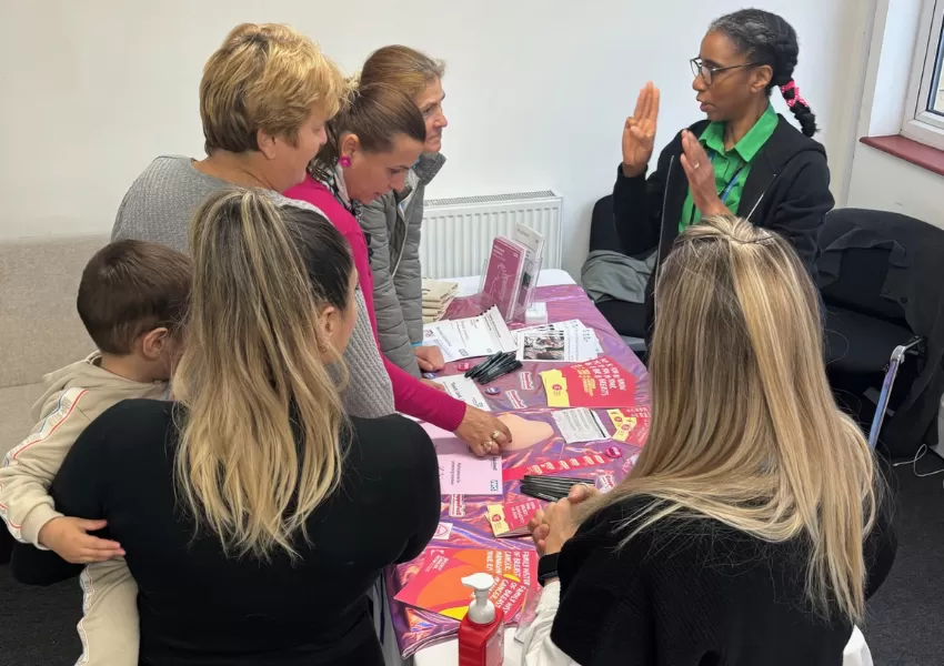 Picture of a female speaking & raising cancer awareness to a group of females.