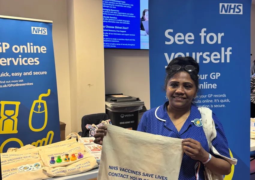 Person holding a totebag promoting vaccine information.