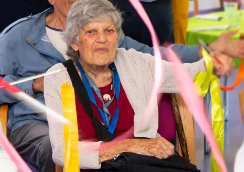 Lady sitting in a chair with ribbons around her.