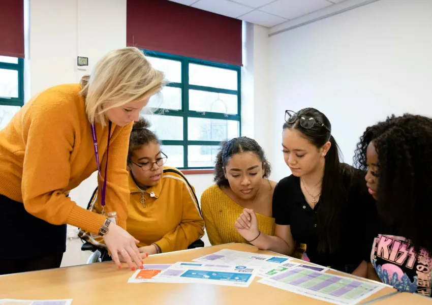 A female teacher talking to young people
