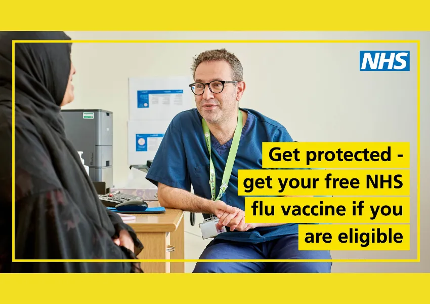 Male nurse wearing blue medical scrubs and leaning on desk, smiling, speaking to female patient wearing grey head covering and smiling. Image has a  yellow border, with black writing on yellow background that says 'get protected - get your free NHS flu vaccine if you are eligible.'