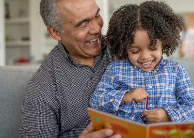 Grandfather and grandchild reading a book together