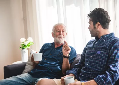 older man and younger man chatting on a sofa