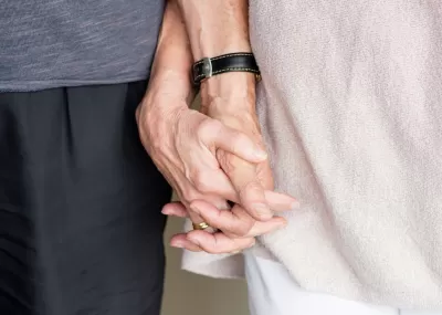 Picture of two individuals holding hands