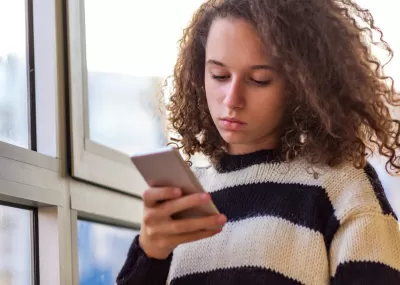 A young person looking at her phone.